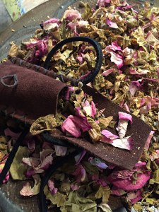 Sacred blend being stuffed in leather pouch for around the neck